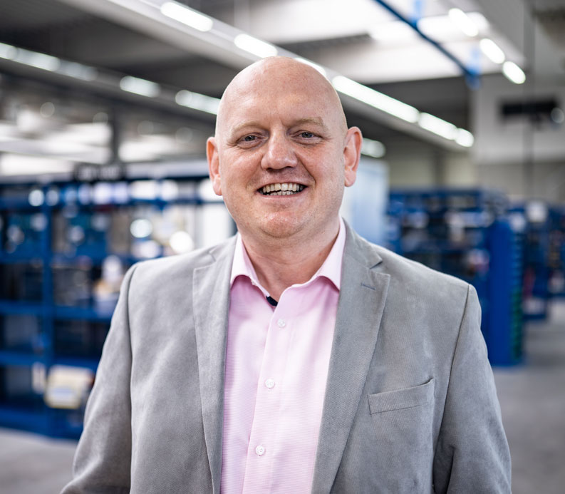 Daniel Schulte or head of international sales. a middle aged man, bald yet still handsome with a friendly smile